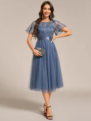 Robe midi d'invitée de mariage en tulle avec ornements et manches transparentes
